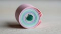 Rolled stack of pastel colored paper featuring layers of pink teal Royalty Free Stock Photo
