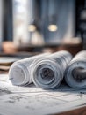Rolled up architectural blueprints and floor plans on a desk in a modern office space with soft natural lighting and blurred Royalty Free Stock Photo