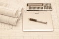 Rolled-up architectural plans with tablet and calculator Royalty Free Stock Photo