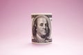 Rolled up bill on a pink background. 100 dollars. Money Royalty Free Stock Photo