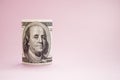 Rolled up bill on a pink background. 100 dollars. Money Royalty Free Stock Photo