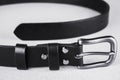 Rolled up black leather belt with silver buckle and rivets Royalty Free Stock Photo