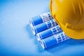 Rolled up construction plans hard hat on blue background Royalty Free Stock Photo