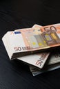 Rolled up euros with rubber on the fifty euro banknotes pile. Money bunch stack Royalty Free Stock Photo