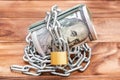 Rolled up money with chain and padlock on the table Royalty Free Stock Photo