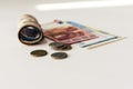 Rolled up money euro banknotes and coins on white background Royalty Free Stock Photo