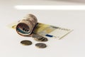 Rolled up money euro banknotes and coins on white background Royalty Free Stock Photo