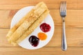 Rolled up pancakes in plate, peach, blueberry, raspberry jam Royalty Free Stock Photo