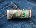 Rolled up paper hundred dollar bills and tightened with green rubber band Royalty Free Stock Photo