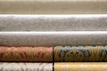 Rolled up rolls of vinyl wallpaper. Different textures and colors, as background, wallpaper with pattern for wall. Decorative Royalty Free Stock Photo