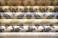 Rolled up rolls of vinyl wallpaper. Different textures and colors, as background White wallpaper with beige, purple