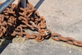 rolled up rusty chain on concrete ground
