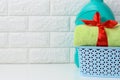 A rolled up terry green towel tied with a red silk ribbon and a plastic bottle of liquid laundry powder on a white shelf in the Royalty Free Stock Photo