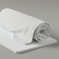 A rolled white fabric placed on top of a stack of lined paper, positioned on a smooth Royalty Free Stock Photo