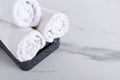 Rolled white fresh towels in the bathroom basket on the white marble floor.Empty space for text Royalty Free Stock Photo