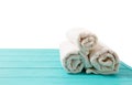 Rolled white towels on blue wooden table isolated on white background. Copy space and top view. Bathroom objects for shower body Royalty Free Stock Photo