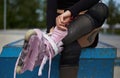 Aggressive inline skater girl put on roller blades. Unrecognizable female athlete in protective knee pads putting on skates on her Royalty Free Stock Photo