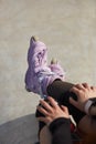 Feet of a young inline skater girl sitting on top of a ramp in a concrete skatepark. Aggressive in-line roller blader female Royalty Free Stock Photo