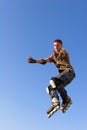 Roller boy jumping from parapet on the blue sky Royalty Free Stock Photo