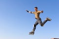 Roller boy jumping from parapet on the blue sky Royalty Free Stock Photo