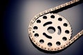 Roller chain with sprocket on dark background. It is used on cars, motorcycles, bicycles and in mechanical engineering. Royalty Free Stock Photo