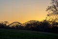 Roller Coaster Over A Hill With A Fiery Sunset