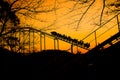Roller coaster train is going up at autumn sunset