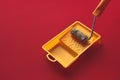 Home Repair Creativity Concept. Roller For Paint And Painting Capacity On Red Background Surface