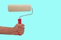 Roller for paintin, the palm of your hand, repair concept, for painted surface, isolated blue background