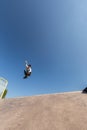 A roller skater jumps a ramp doing a trick in a skate park Royalty Free Stock Photo