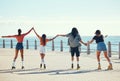 Roller skaters, friends and holding hands at a beach for exercise, fitness and freedom in summer together. Group, male Royalty Free Stock Photo