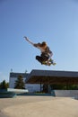 Roller skating concept, young male skater jumping high on ramp Royalty Free Stock Photo