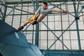 Rollerblader jump high from big air ramp performing trick. Indoors skate park equipment. Royalty Free Stock Photo