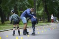 Rollerblading. Boys practicing in artistic slalom in a city park