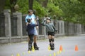 Rollerblading. Man trainer fooling around with boys in a park