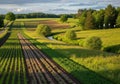 A curving stream cuts through the fields, lined with trees and shrubs Royalty Free Stock Photo