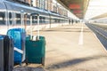 Rolling bags, luggage suitcases on the platform of the railway passenger empty station next to the train, destination