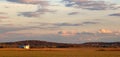 Rolling Farm Fields with Grain Bins in the Distance with Sunset Sky Royalty Free Stock Photo