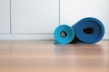 Rolling or folding blue yoga mat after a workout,Exercise equipment Healthy fitness and sport concept Royalty Free Stock Photo