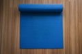 Rolling or folding blue yoga mat after a workout,Exercise equipment Healthy fitness and sport concept Royalty Free Stock Photo