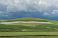 Rolling green farm fields with angry storm Royalty Free Stock Photo