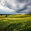 Rolling green fields stretch across the landscape under a dramatic, cloudy sky Royalty Free Stock Photo