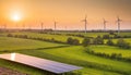 Rolling green hills with wind turbines and a solar panel array at sunset Royalty Free Stock Photo
