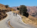 Two cyclists riding on winding trail in California