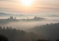 Rolling hills covered in a thick layer of fog under a soft, pastel-colored sky at dawn. Royalty Free Stock Photo