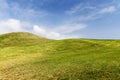 Rolling hills field and a beautiful sky with fluffy clouds