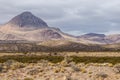 Rolling hills and small mountain behind vast desert vista landscape Royalty Free Stock Photo