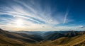 Rolling hills and valleys under a bright sun with a broad sky filled with scattered Royalty Free Stock Photo