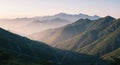 Rolling mountains covered in dense green forests stretch into the distance, creating a Royalty Free Stock Photo