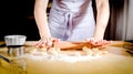 Female hands rolling out dough on kitchen table, close up Royalty Free Stock Photo